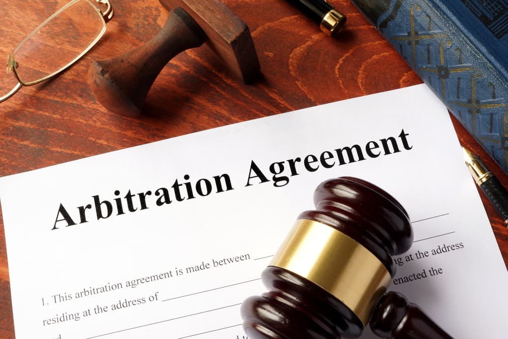 An arbitration agreement document placed on an office table.